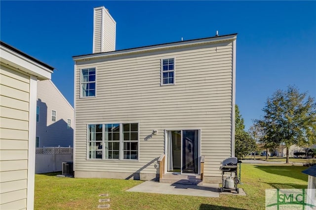 back of property with a patio, central AC, and a lawn