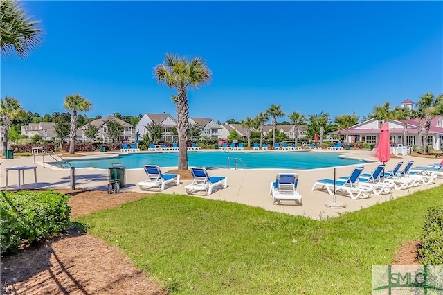 view of swimming pool with a patio area and a yard