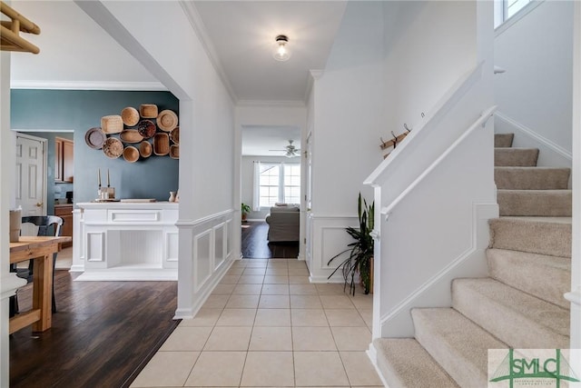 entrance foyer featuring ceiling fan, ornamental molding, and light hardwood / wood-style flooring