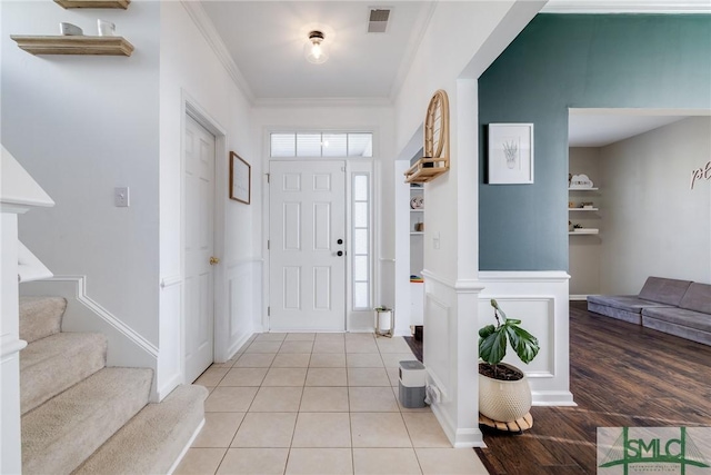 entryway with light wood-type flooring and crown molding