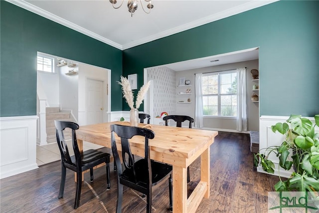 dining room featuring dark hardwood / wood-style flooring, crown molding, and an inviting chandelier