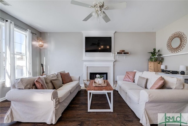 living room featuring ceiling fan and dark wood-type flooring