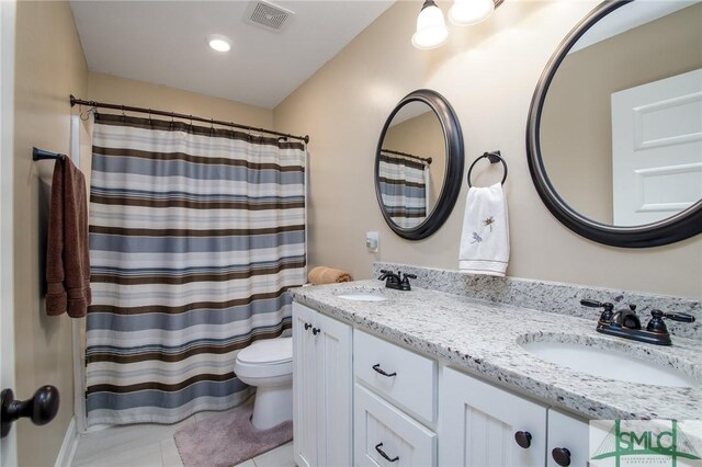 bathroom featuring tile patterned flooring, vanity, toilet, and curtained shower