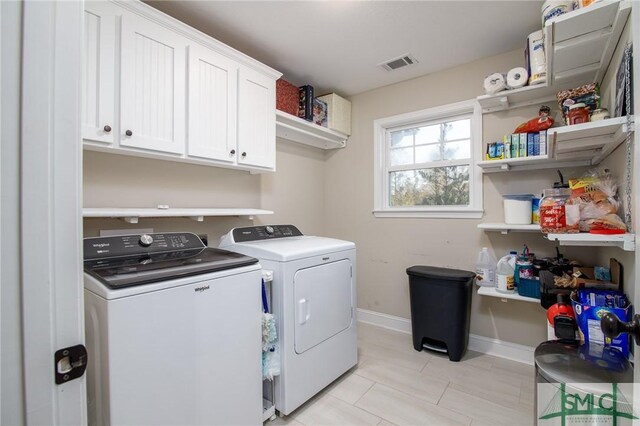 laundry area with washer and dryer and cabinets