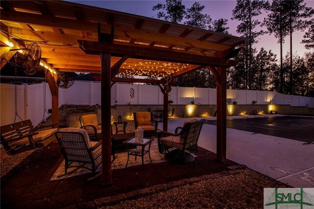 patio terrace at dusk featuring a pergola and outdoor lounge area