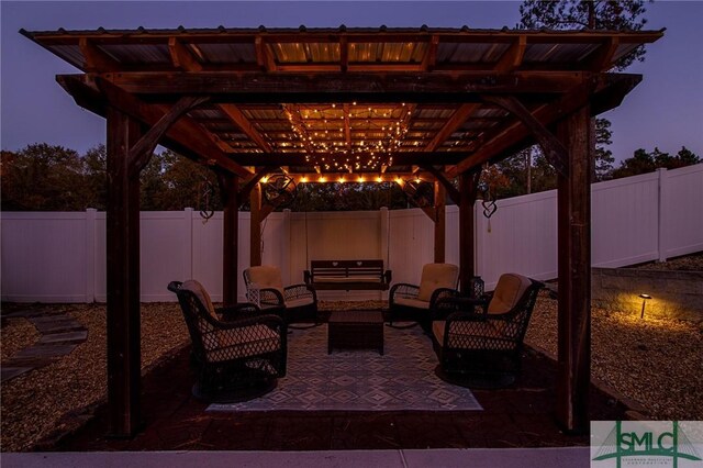 patio terrace at dusk with an outdoor living space and a pergola