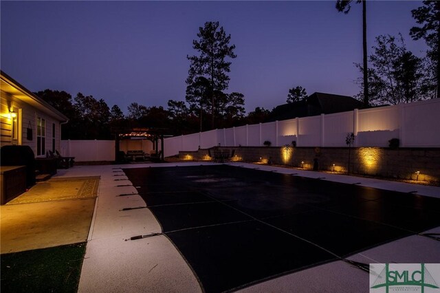 pool at dusk featuring a patio area