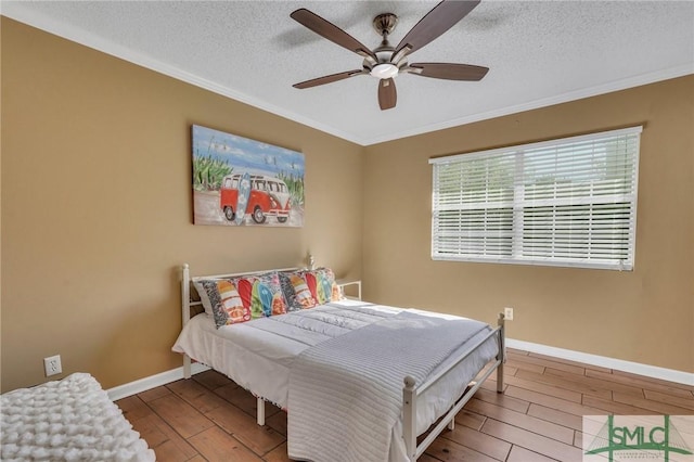 bedroom with ceiling fan, crown molding, a textured ceiling, and hardwood / wood-style flooring