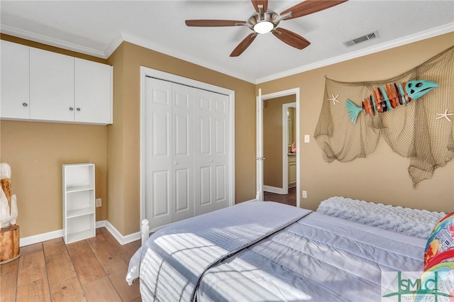 bedroom featuring ceiling fan, a closet, ornamental molding, and light hardwood / wood-style flooring