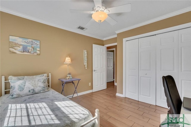 bedroom with ceiling fan, a closet, ornamental molding, and light wood-type flooring