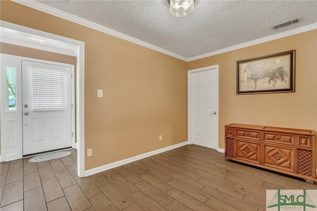 foyer with ornamental molding, a textured ceiling, and light hardwood / wood-style flooring