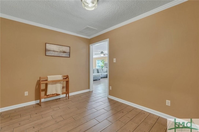 empty room with a textured ceiling, light hardwood / wood-style flooring, and ornamental molding