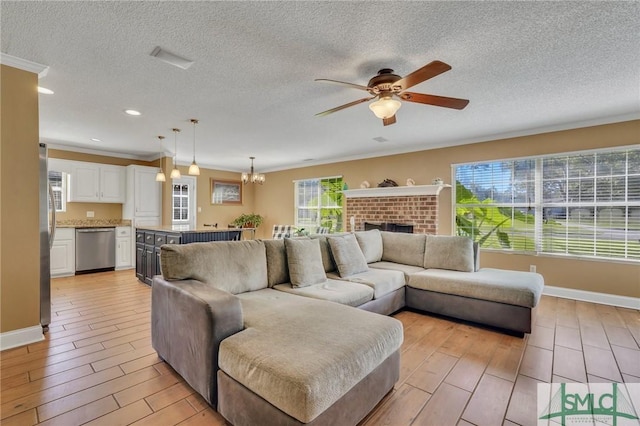 living room featuring a textured ceiling, ceiling fan with notable chandelier, light hardwood / wood-style flooring, and a healthy amount of sunlight