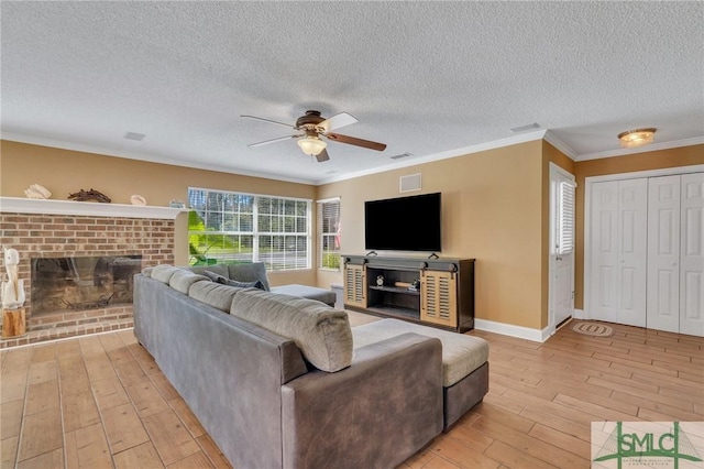 living room with crown molding, light hardwood / wood-style flooring, ceiling fan, and a textured ceiling