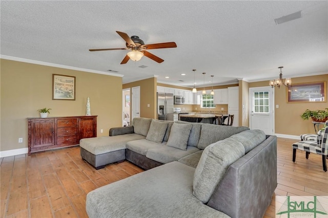 living room featuring ceiling fan with notable chandelier, light hardwood / wood-style floors, ornamental molding, and a textured ceiling