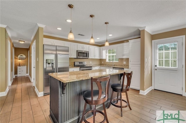 kitchen with plenty of natural light, a center island, white cabinetry, and stainless steel appliances