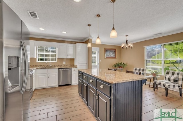 kitchen featuring pendant lighting, a center island, light wood-type flooring, white cabinetry, and stainless steel appliances