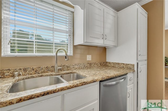 kitchen featuring white cabinets, dishwasher, sink, and a textured ceiling