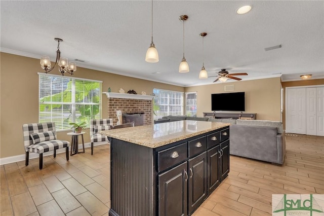 kitchen with decorative light fixtures, a kitchen island, plenty of natural light, and light hardwood / wood-style floors