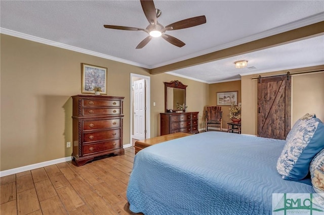 bedroom featuring ceiling fan, a barn door, crown molding, a textured ceiling, and light wood-type flooring