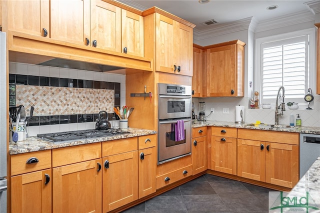 kitchen featuring decorative backsplash, light stone counters, sink, and stainless steel appliances