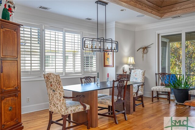 dining room featuring crown molding, an inviting chandelier, a healthy amount of sunlight, and light hardwood / wood-style floors