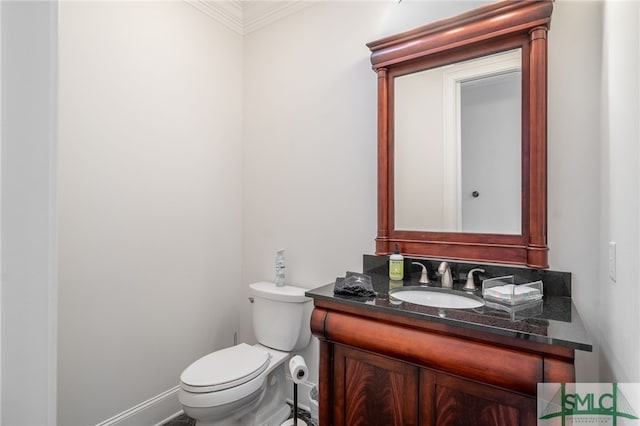 bathroom featuring toilet, vanity, and ornamental molding