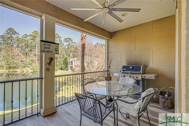 sunroom / solarium with a water view and ceiling fan