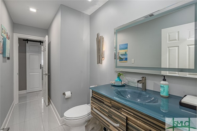 bathroom featuring toilet, vanity, and tile patterned floors