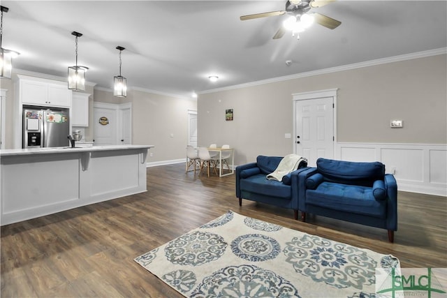 living room featuring ceiling fan, crown molding, and dark wood-type flooring