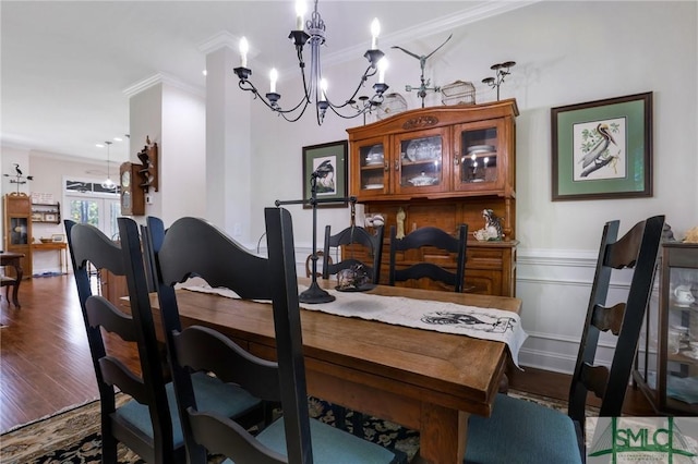 dining area featuring hardwood / wood-style floors, crown molding, and an inviting chandelier