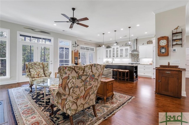 living room with sink, dark hardwood / wood-style flooring, ceiling fan, and ornamental molding