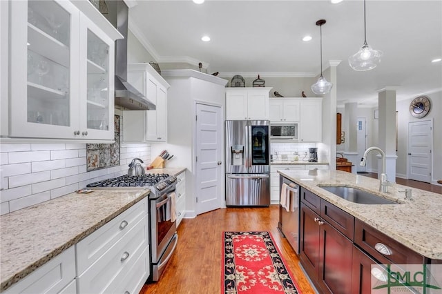 kitchen featuring sink, hanging light fixtures, ornamental molding, light hardwood / wood-style floors, and stainless steel appliances