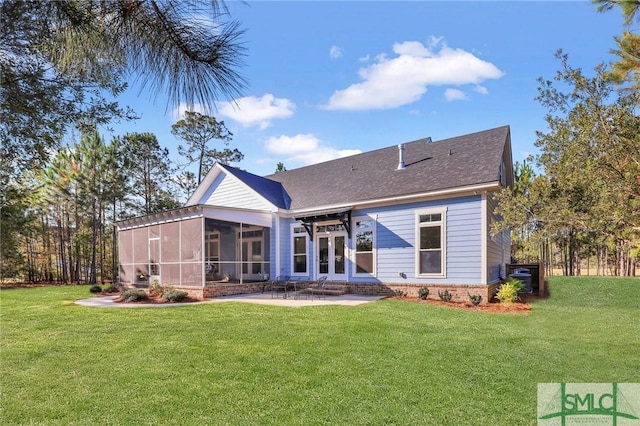 rear view of property with a sunroom, a patio area, and a lawn