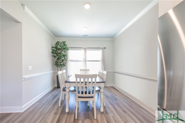 unfurnished dining area with light hardwood / wood-style floors and crown molding