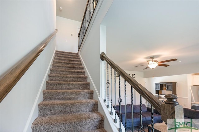 stairs featuring ceiling fan