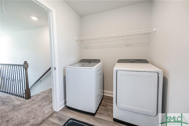 washroom with independent washer and dryer and light hardwood / wood-style floors