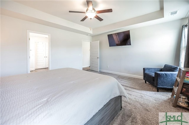 bedroom featuring carpet flooring, a raised ceiling, and ceiling fan