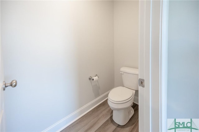 bathroom with hardwood / wood-style floors and toilet