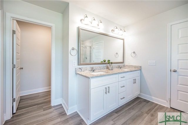 bathroom featuring vanity, hardwood / wood-style flooring, and a shower with shower door