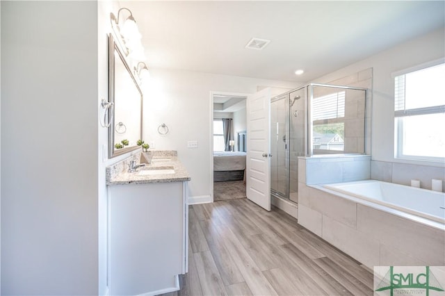 bathroom with hardwood / wood-style flooring, vanity, and independent shower and bath