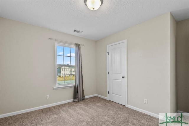 carpeted spare room featuring a textured ceiling