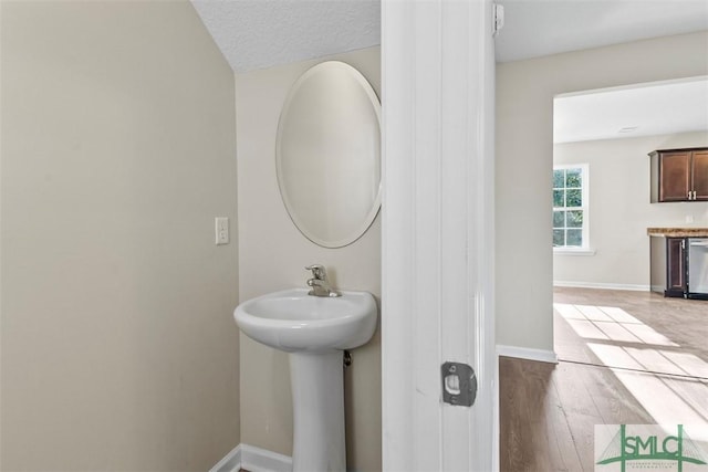 bathroom featuring hardwood / wood-style floors and a textured ceiling