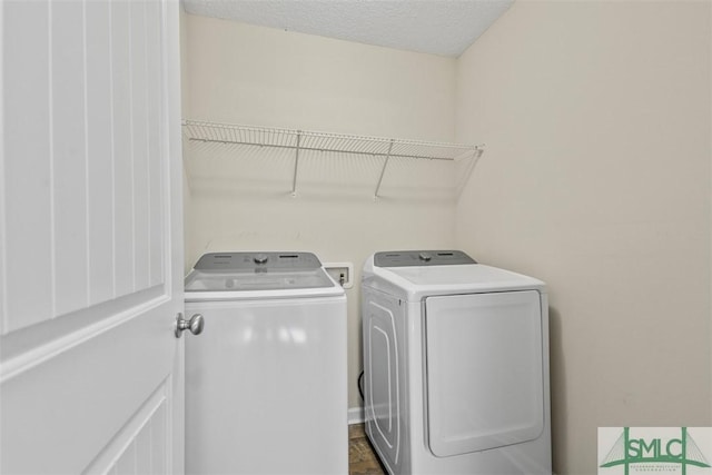 laundry area with a textured ceiling and washer and clothes dryer