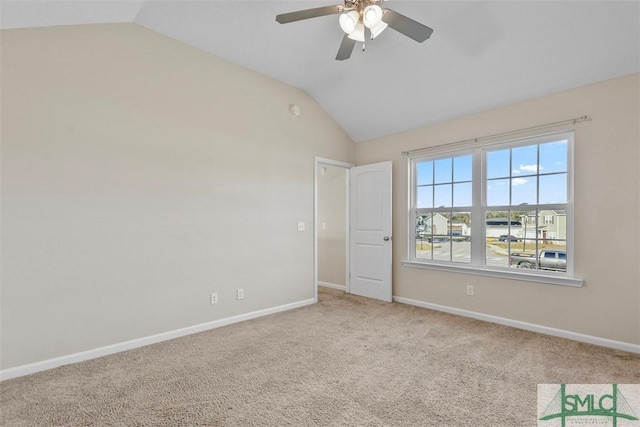 carpeted spare room with ceiling fan and lofted ceiling