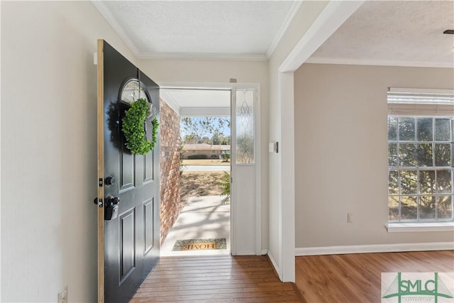 entrance foyer featuring crown molding, a textured ceiling, and hardwood / wood-style flooring