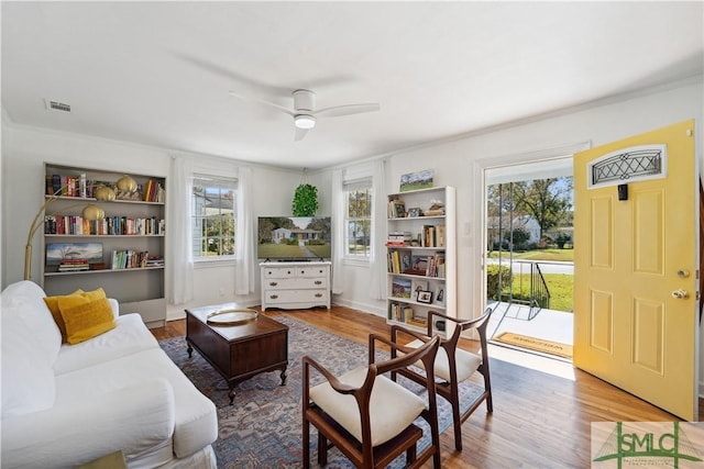 sitting room with ceiling fan, hardwood / wood-style floors, and ornamental molding