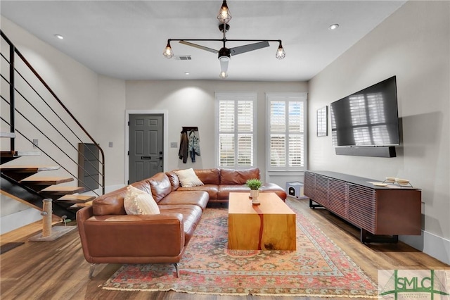 living room featuring hardwood / wood-style floors and ceiling fan