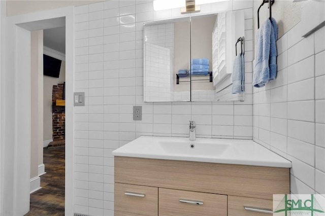 bathroom with vanity, hardwood / wood-style floors, and tile walls