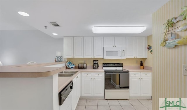3 3rd St Unit 517, Tybee Island, GA 31328 - kitchen featuring white appliances, a peninsula, wallpapered walls, light countertops, and light tile patterned floors